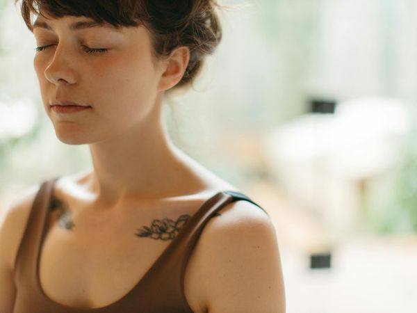 Person meditating peacefully in a calm, minimalist environment.